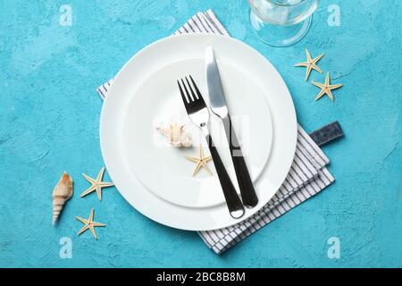 Tischeinstellung mit Seashells und Starfishes auf türkisfarbenem Hintergrund, Draufsicht Stockfoto
