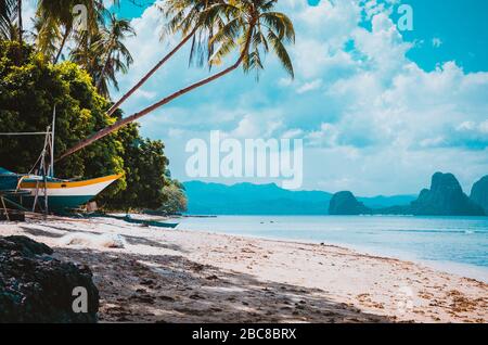 Banca Boot an Ufer unter Palmen.tropische Insel landschaftlich reizvolle Landschaft. El-Nido, Palawan, Philippinen, Südost-Asien Stockfoto