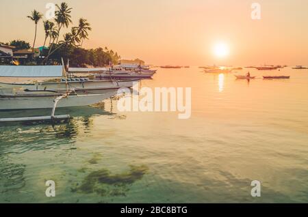 Sonnenuntergang am Strand mit Silhouette des banca-bootes auf der Insel Panglao, Bohol, Philippinen. Stockfoto