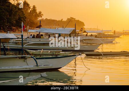 Sonnenuntergang am Strand mit Silhouette des banca-bootes auf der Insel Panglao, Bohol, Philippinen. Stockfoto