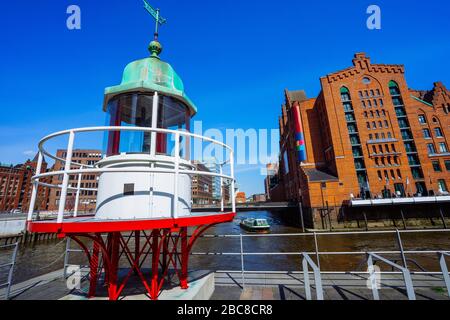 Altes Leuchtfeuer oder kleiner Leuchtturm in der Nähe des Flusskanals in der Hamburger Hafencity. Stockfoto