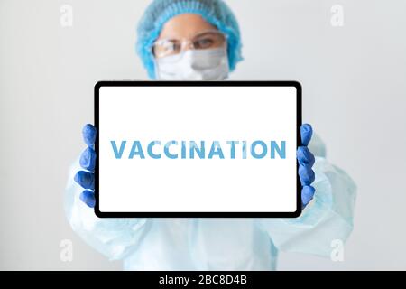 Arzt mit einer digitalen Tablette. Auf dem Bildschirm mit der Aufschrift "Impfung" Stockfoto