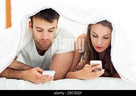 Koppeln mit Smartphones im Bett Stockfoto
