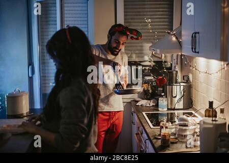 Glückliches Paar bereitet Weihnachtsessen in der Küche Stockfoto