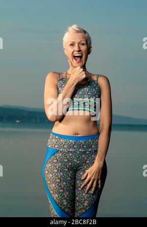 IKYA-Meditation, Frau in Sportswear fröhlich am See Stockfoto