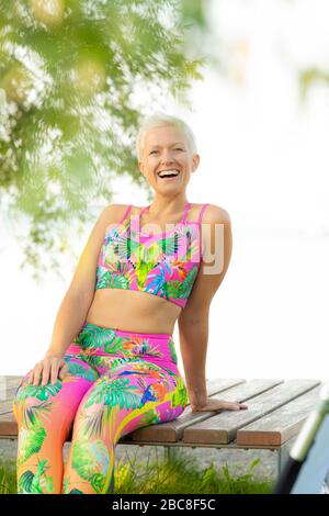 IKYA-Meditation, Frau in Sportswear fröhlich am See Stockfoto