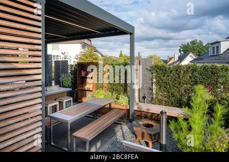 Moderne überdachte Terrasse mit Sitzgelegenheiten und Kamin Stockfoto