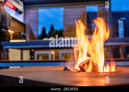 Offenes Feuer in einer Außenküche in der Nähe einer Grillplatte Stockfoto