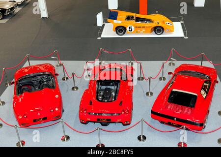 Luftaufnahme von drei roten Ferraris (links nach rechts: Testarossa, Enzo und einem Ferrari 550 Barchetta) und einem McLaren M8D auf der Londoner Classic Car Show 2020 Stockfoto