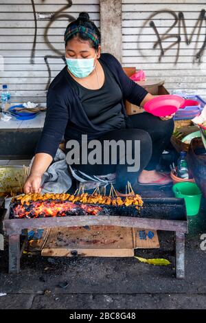 Vertikaler Blick auf einen Stall, der Sate, ein traditionelles Gericht auf Bali, von der Seite der Straße aus verkauft. Stockfoto