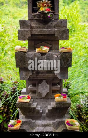 Vertikaler Blick auf hübsche handgefertigte Blumenkörbe, die als Segnungen auf einem Altar in Bali, Indonesien verwendet werden. Stockfoto