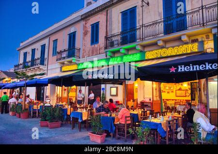 Menschen, die in Bars in Cefalu, Italien, essen und trinken Stockfoto