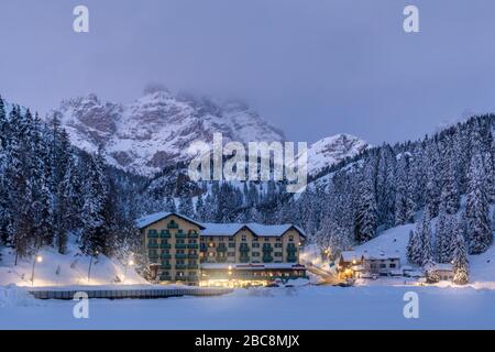 Misurina Winterpanorama, eines der Touristenhotels, hinter dem Monte Rudo - Rautkofel und Croda dei Rondoi - Schwalbenkofel, Auronzo di Cadore, Bellu Stockfoto