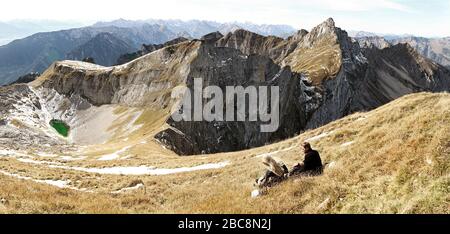 Rofan-Berge am Achensee mit Blick auf Spieljoch und Hochiss im Vordergrund und Karwendel im Hintergrund mit zwei ruhenden Wanderern und A. Stockfoto