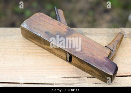 Alter Holzbalken auf Holzhintergrund, Holzarbeiter-Werkzeug Stockfoto