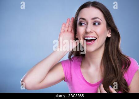 Frau mit Hand-zu-Ohr-Zuhören Stockfoto