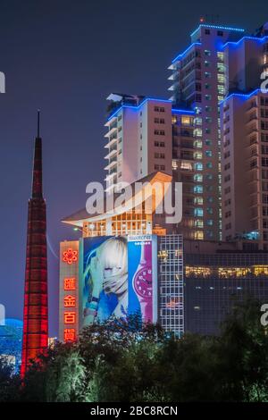 Shanghai, Xuhui, China - 3. Mai 2010: Nachtporträt. Der farbenfroh beleuchtete Wolkenkratzer in Wohnhäusern überzieht dunkle Bäume des Xujiahui Park. Rot schlank bis Stockfoto