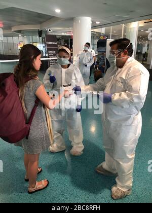 Medizinstudenten, die ankommende Passagiere auf Anzeichen von COVID-19, Coronavirus am San Juan International Airport 21. März 2020 in San Juan, Puerto Rico, untersuchen. Stockfoto