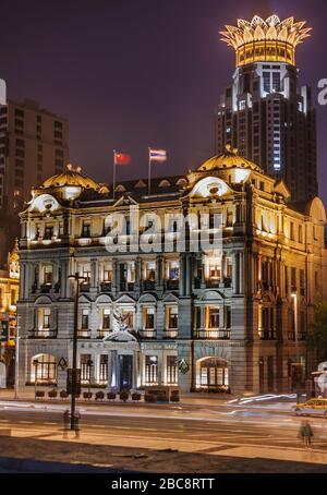 Shanghai, China - 4. Mai 2010: Nachtporträt des farbenfroh beleuchteten historischen Gebäudes der Bangkok Bank auf dem Bund mit der krönenden Spitze des Finanzzentrums in Stockfoto