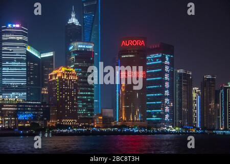 Shanghai, Pudong, Lujiazui, China - 4. Mai 2010: Nächtliche Skyline von farbenfroh beleuchteten Wolkenkratzern rund um den Aurora-Turm über dem Fluss Huangpu, wie sie zu sehen sind Stockfoto