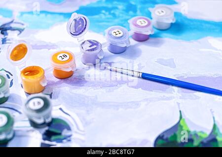 Bild nach Zahlen. Zeichnen auf Leinwand. Nummerierte Farbdosen. Kreatives Hobby. Selektiver Fokus. Nahaufnahme. Stockfoto