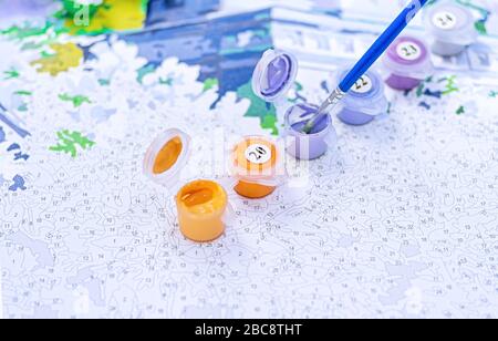 Bild nach Zahlen. Zeichnen auf Leinwand. Nummerierte Farbdosen. Kreatives Hobby. Selektiver Fokus. Nahaufnahme. Stockfoto