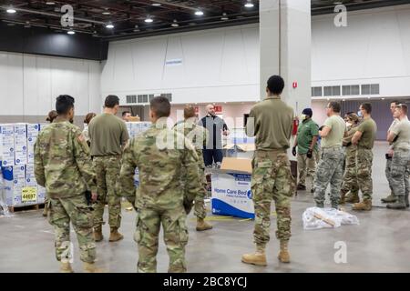 Detroit, Michigan, USA. April 2020. Arbeiter bauen ein Notarztkrankenhaus im TCF-Kongresszentrum auf. Das Krankenhaus mit 1.000 Betten wird Covid-19-Patienten versorgen. Soldaten der Nationalgarde von Michigan erfahren, wie man Betten zusammenstellt. Kredit: Jim West/Alamy Live News Stockfoto