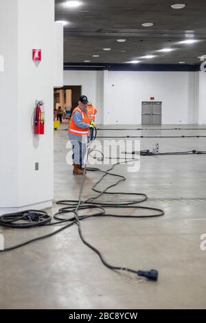 Detroit, Michigan, USA. April 2020. Ein Elektriker führt die Verkabelung für ein Notfall-Feldkrankenhaus im TCF-Kongresszentrum durch. Das Krankenhaus mit 1.000 Betten wird Covid-19-Patienten versorgen. Kredit: Jim West/Alamy Live News Stockfoto