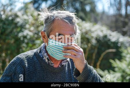 Portrait eines 75-jährigen alten Mannes in einer medizinischen Maske. Ein Konzept der Gefahr von Coronavirus für ältere Menschen. Stockfoto