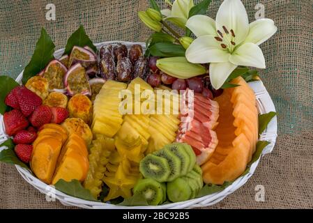 Gesunde frische Früchte in einem Korb auf Tisch geschnittenes Obst in einem Korb Kiwi-Ananas-Erdbeere. Stockfoto