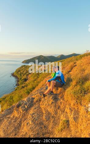 Paare, die bei Sonnenuntergang den Blick auf die Insel beobachten, Drawaqa Island, Yasawa-Inselgruppe, Fiji, Südpazifische Inseln, Stockfoto