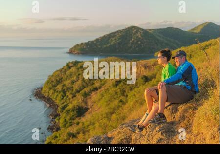 Paare, die bei Sonnenuntergang den Blick auf die Insel beobachten, Drawaqa Island, Yasawa-Inselgruppe, Fiji, Südpazifische Inseln, Stockfoto