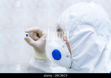 Blaue und weiße Pille in den Ärzten Hand mit Handschuhen Nahaufnahme. Konzept zur Heilung von Krankheiten, selektiver Fokus. Stockfoto