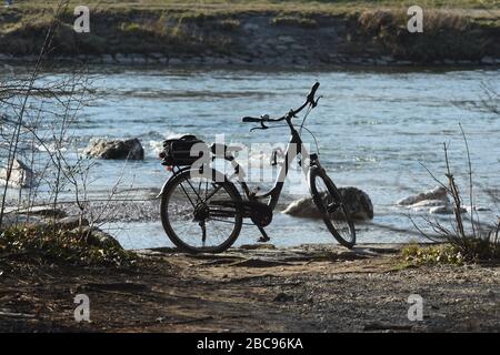 München, Deutschland. April 2020. Bei strahlendem Sonnenschein parkt am Isarufer in der Nähe des Zoos Hellabrunn ein Fahrrad. Kredit: Felix Hörhager / dpa / Alamy Live News Stockfoto