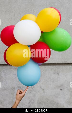 Hand balancieren eine Menge von Ballons Stockfoto