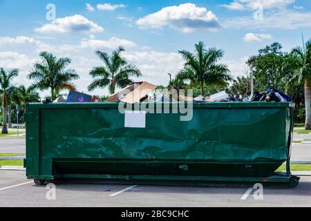 Große Müllcontainer aus grünem Metall, gefüllt mit Müll auf dem Parkplatz - Davie, Florida, USA Stockfoto