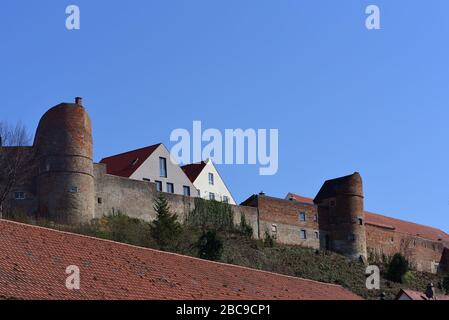 Historische Stadtmauer Friedbergs in Bayern mit Türmen gegen blauen Himmel und mit Kacheln überzogenen Dächern Stockfoto