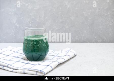 Gesundes Smoothie mit Spirulina auf neutralem Hintergrund mit Leerzeichen für Text Stockfoto