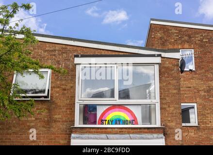 Mit einer "Stay at Home"-Nachricht und einem Regenbogen in einem Fenster auf der Höhe der Coronavirus-Pandemie von 2020 in Southampton, England, Großbritannien, unterschreiben Stockfoto