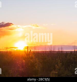 Sonnenuntergang vor dem Hintergrund der großen übergewichtigen Wolken. Stockfoto