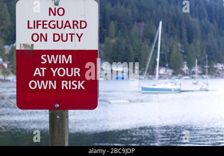 Ein Schild warnt "No Lifeguard on Duty", "wim at Your Own Risk" in Deep Cove, Kanada Stockfoto