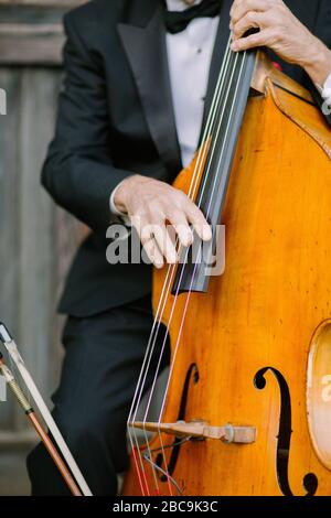 Nahaufnahme eines Cellos, das in formaler Kleidung gespielt wird Stockfoto