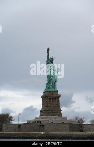 Die Freiheitsstatue vom Meer mit einem gemischten Himmel dahinter Stockfoto