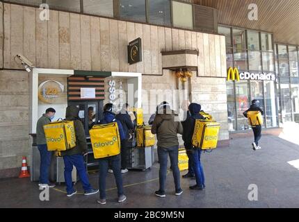 Kiew, Ukraine - 3. April 2020: Kuriere des Glovo Delivery Service warten in einer Linie bei McDonalds Express während der COVID-19-Quarantäne in Kiew, wenn alle Restaurants nur im Liefermodus arbeiten Stockfoto