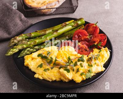 Rührei mit gebratenem Tomatenspargelfrühstück, gesundes Essen Stockfoto