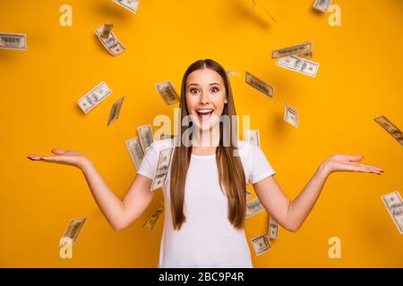 Porträt des staunenden positiven Mädchen-Hüpfers genießen Freude Geld fallen Fliege halten Hände beeindruckt Schrei Wow omg tragen weißes T-Shirt isoliert über hell Stockfoto