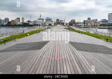 Das malerische Architekturdesign des Yokohama Passenger Terminal (Osanbashi Pier) mit der Skyline der Stadt im Hintergrund, Japan Stockfoto