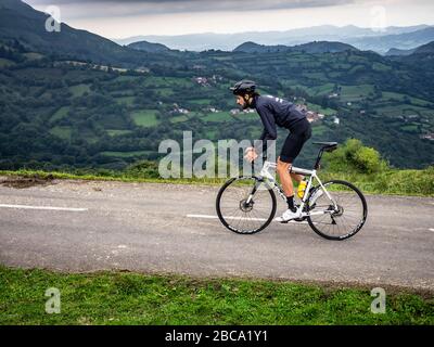 Straßenradsport in Asturien, Nordspanien. Radfahrer auf der Bergstraße zum Gipfel von Angliru, einer sagenhaften Bergankunft der Vuelta a España Stockfoto