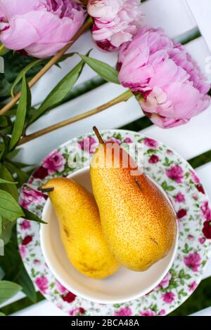 Rosarote Pfirsich und gelbe Birnen leben noch im Garten Stockfoto