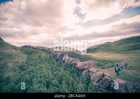 Touristen, die in der Nähe von St Abbs Heads in der Nähe eines kleinen Fischerdorfes an der Südostküste Schottlands, Berwickshire in Großbritannien, spazieren Stockfoto